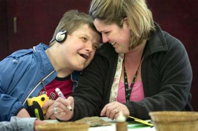 
Recreational therapist Maria Goff (cq) smiles at Ron Taylor (cq) who leant his head on her shoulder while she was helping him make a Mother's Day card at The Arc Community Center Friday afternoon, May 12, 2006. Taylor loves listening to opera on his headphones. The Arc Community Center serves people with developmental disabilities, providing opportunities for social interaction and recreation through crafts, classes, sports, games, dances, discussion groups, service projects and outings in the community. Holly Pickett 
 (Holly Pickett / The Spokesman-Review)