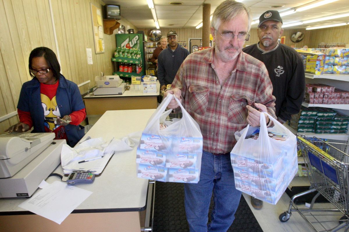 Clerk Debra Brinkley, left, checks out customers as longtime Hostess thrift store customer Mark Talley leaves the Memphis, Tenn., store with bags full of Zingers on Friday. (Associated Press)