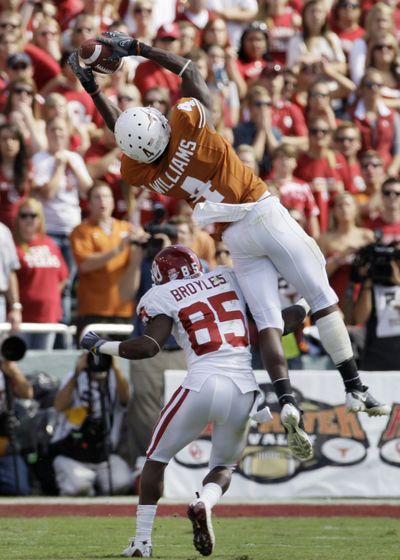 Texas cornerback Aaron Williams (4) goes up high to intercept a pass during the second half Saturday.  (Associated Press / The Spokesman-Review)