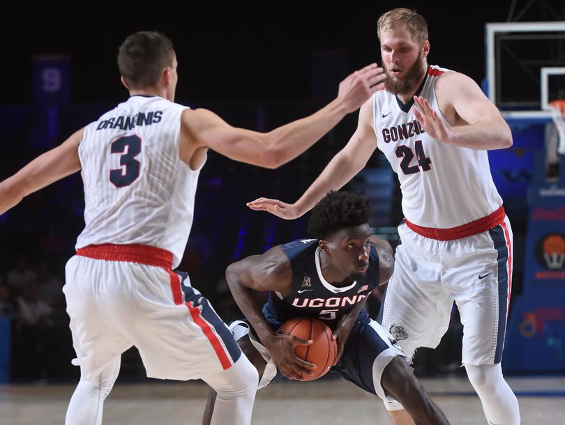 Connecticut forward Daniel Hamilton  tries to squeeze between Gonzaga guard Kyle Dranginis (3) and  center Przemek Karnowski  during the Battle 4 Atlantis NCAA men’s college basketball tournament in Paradise Island, Bahamas.