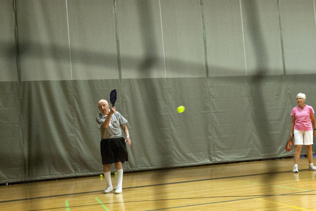 Don Smithgall serves the ball along with his partner Carolyn Pilcher during a game of Pickleball at The HUB Sports Center in Liberty Lake on Monday, June 12, 2017. (Kathy Plonka / The Spokesman-Review)