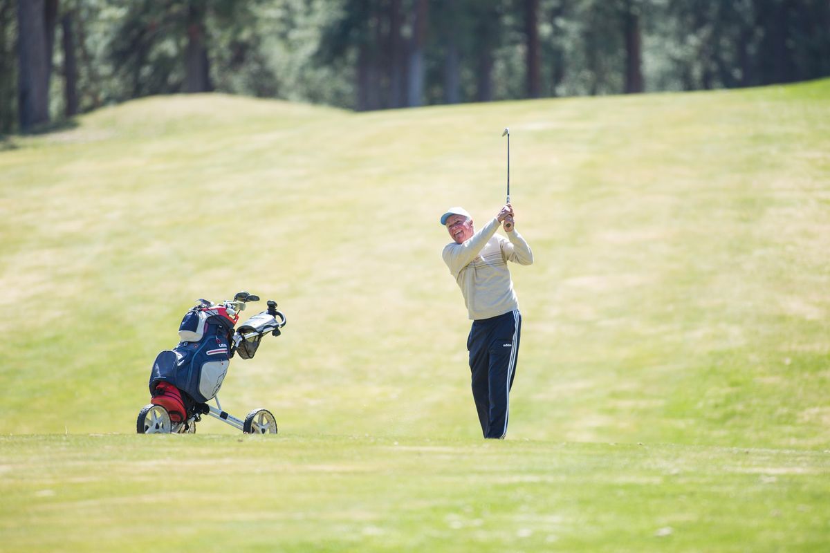 A man drives down the fairway to the ninth hole at The Highlands Golf and Country Club on a sunny Monday, April 13, 2020 in Post Falls, Idaho. (Libby Kamrowski / The Spokesman-Review)