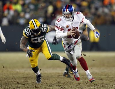 New York Giants quarterback Eli Manning, right, runs against Green Bay Packers outside linebacker Julius Peppers during the second half of an NFC wild-card NFL football game, Sunday, Jan. 8, 2017, in Green Bay, Wis. (Matt Ludtke / Associated Press)