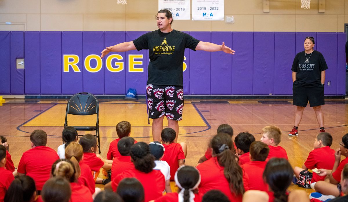 Football player Levi Horn, who played a few years with the Vikings and Bears and played in the Canadian Football League, too, talks with the kids gathered at Rogers High School for the Rise Above sports camp Monday, July 11, 2022. Athletes and coach of note attended to help coach the kids through drills and workouts.  (Jesse Tinsley/The Spokesman-Review)