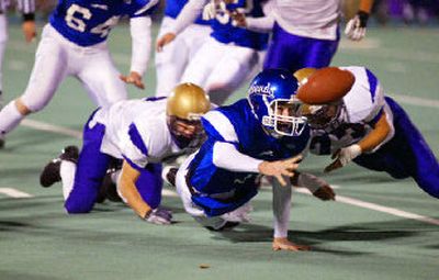 
Pullman quarterback J.T. Levenseller laterals the ball to a teammate as he's being tackled. 
 (Paul T. Erickson/Tri-City Herald / The Spokesman-Review)