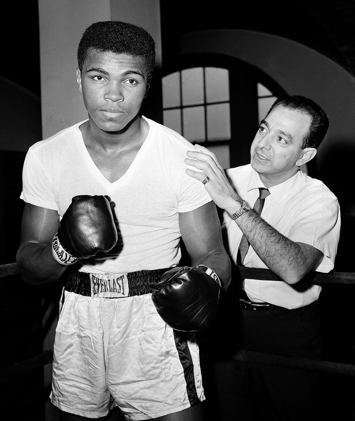 In this Feb. 8, 1962, file photo, a young Muhammad Ali, left, stands with his trainer Angelo Dundee at City Parks Gym in New York.  (Dan Grossi / Associated Press)