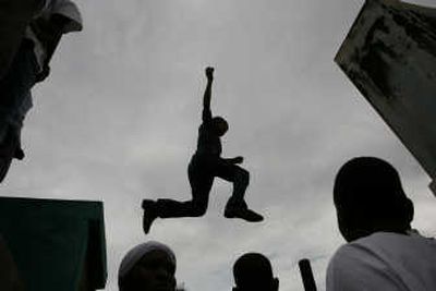 
A man jumps from tomb to tomb Thursday at the National Cemetery in Port-au-Prince in observation of the Day of the Dead.
 (Associated Press / The Spokesman-Review)