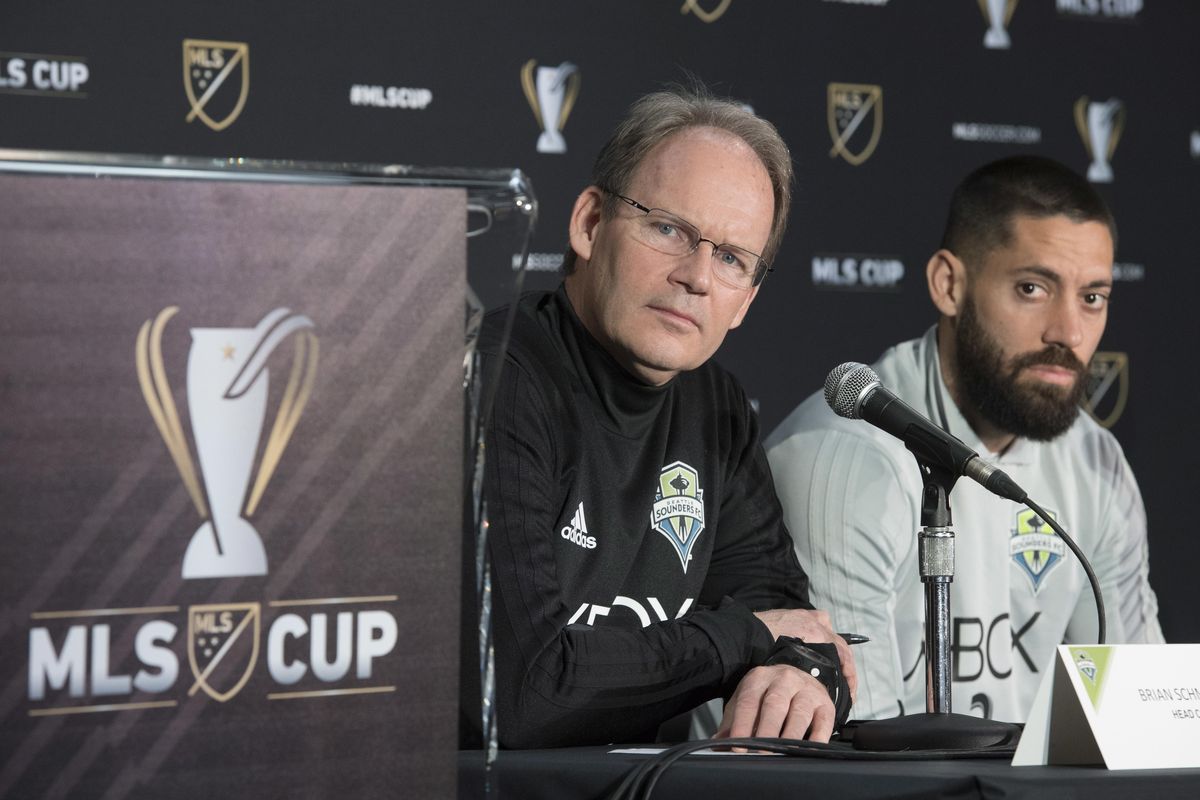 Sounders coach Brian Schmetzer, left, and forward Clint Dempsey listen to a question during a news conference in Toronto on Thursday. The Sounders face Toronto FC in the MLS Cup soccer final on Saturday. (Frank Gunn / Associated Press)
