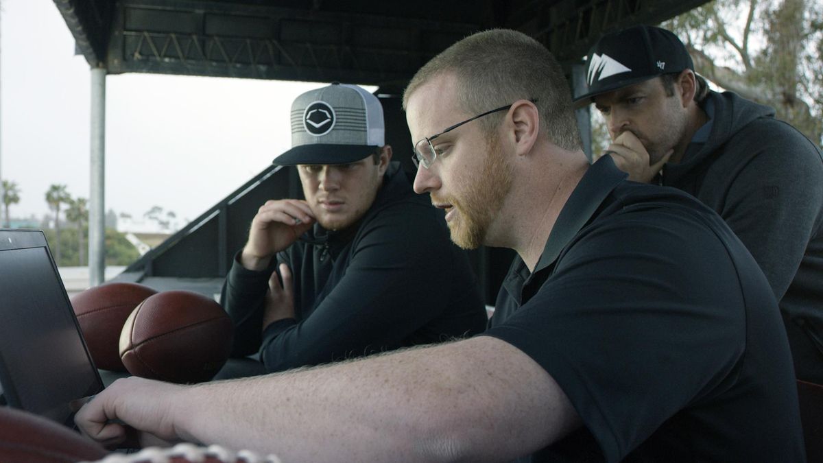 In this April 19, 2018, photo provided by Wilson Sporting Goods, quarterback Sam Darnold, left, and his mentor, former quarterback Jordan Palmer, right, look on as Wilson Labs engineer Dan Hare explains data gathered from throwing a football using the Wilson Connected Football System, at San Clemente High School in San Clemente, Calif. Darnold, the New York Jets rookie quarterback, was at his old stomping grounds in California last month tossing “smart” footballs equipped with computer chips with Palmer, that were calculating his every throw. (Associated Press)