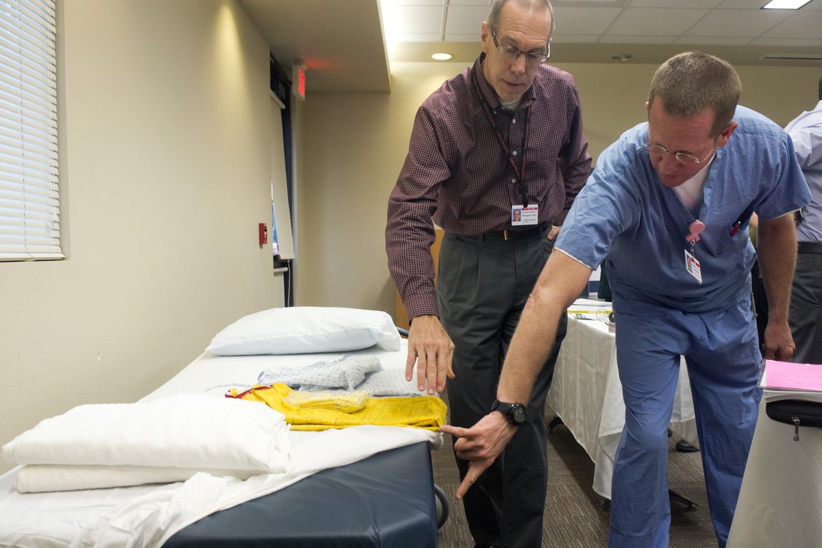Dr. Wayne Tilson, left, and charge nurse Bill Putren point out the new, thicker mattresses on an emergency room bed during an open house Thursday at Valley Hospital. Improvements and additional staff training are designed to make the ER more senior-friendly. (Jesse Tinsley)