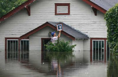 
Associated Press Tony Freez retrieves a framed photo from his boss's home Tuesday in Miami, Okla.
 (Associated Press / The Spokesman-Review)