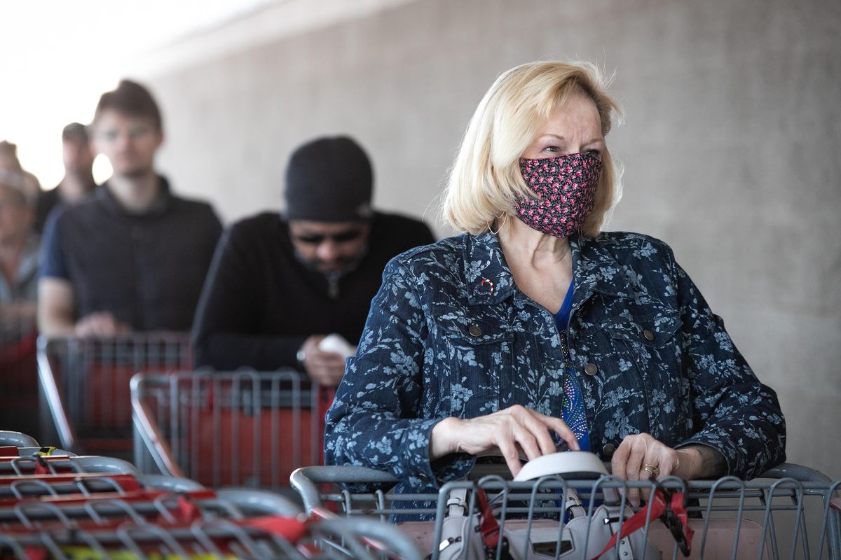 Customers wait in line Thursday to enter the Costco on Sprague Avenue in Spokane Valley. The wholesale store implemented a policy of limiting the number of customers in the store at any given time in order to enforce social distancing to prevent the spread of COVID-19. (Libby Kamrowski / The Spokesman-Review)