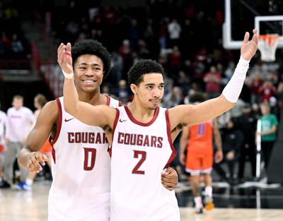 Washington State forward Jaylen Wells (0) and guard Myles Rice (2) celebrate the Cougs 66-61 winb over Boise State during a NCAA college basketball game, Thursday, Dec. 21, 2023, in the Spokane Veterans Arena.  (COLIN MULVANY)