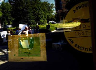 
Protesters are reflected in the development plans of the Copper Ridge neighborhood at Coeur d'Alene City Hall on Tuesday evening. 
 (Brian Plonka / The Spokesman-Review)