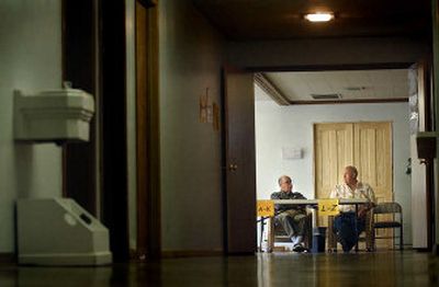 
Polling workers Ed Underhill and Wayne McMorris kill time at The Pentacostals of Spokane Church, waiting for voters during Tuesday's primary election. 
 (Brian Plonka / The Spokesman-Review)