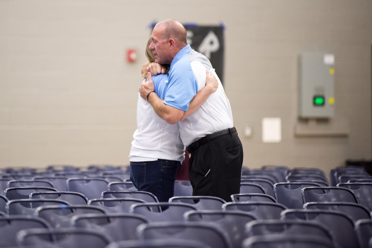 Randy Russell, superintendent of the Freeman schools, hugs another staff member Thursday, Sept. 14, 2017 before a community-wide meeting to discuss the school shooting that took place Wednesday at Freeman High School. The crowd packed the gymnasium and listened to Russell, representatives of the Sheriff’s Department and a mental health professional. (Jesse Tinsley / The Spokesman-Review)