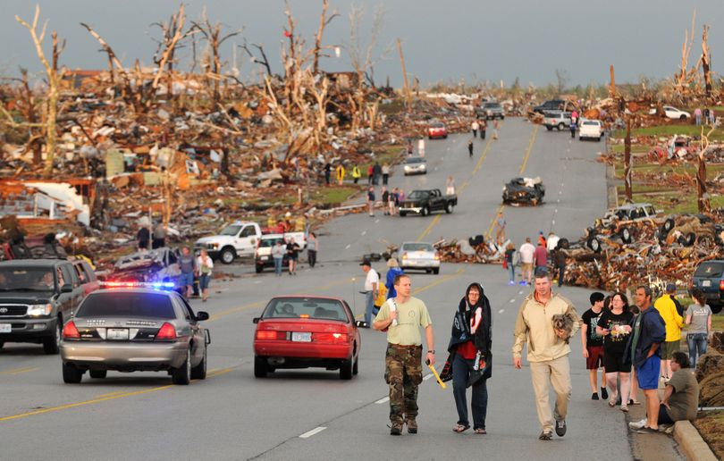 Residents of Joplin, Mo, walk west on 26th Street near Maiden Lane after a tornado hit the southwest Missouri city on Sunday evening, May 22, 2011. The tornado tore a path a mile wide and four miles long destroying homes and businesses. (Mike Gullett / Associated Press)