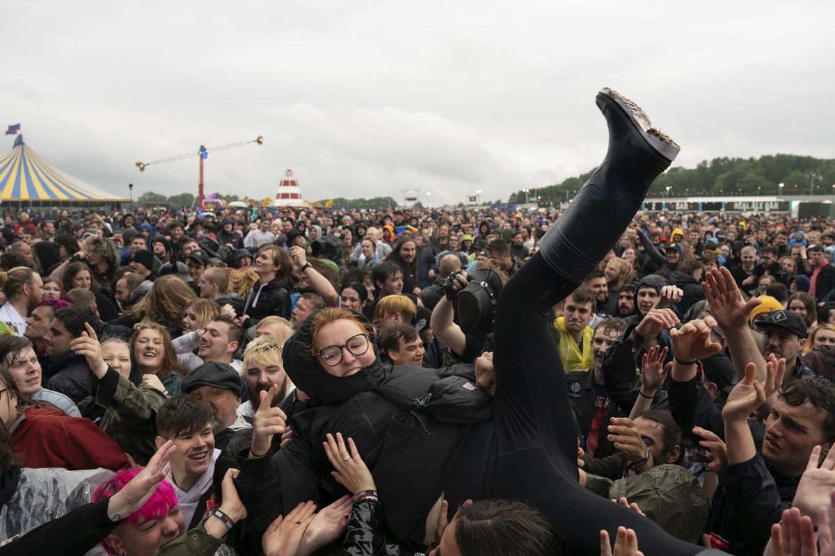 A festivalgoer crowd surfs on the first day of Download Festival at Donington Park at Castle Donington, England, Friday June 18, 2021. The three-day music and arts festival is being held as a test event to examine how Covid-19 transmission takes place in crowds, with the the capacity significantly reduced from the normal numbers.  (Joe Giddens)