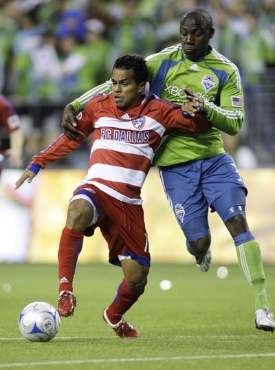 Seattle’s Jhon Kennedy Hurtado, right, grabs Dallas forward. (Associated Press / The Spokesman-Review)