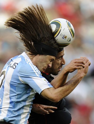 Argentina's Martin Demichelis, left, competes for the ball with Germany's Sami Khedira in World Cup play.  (Associated Press)