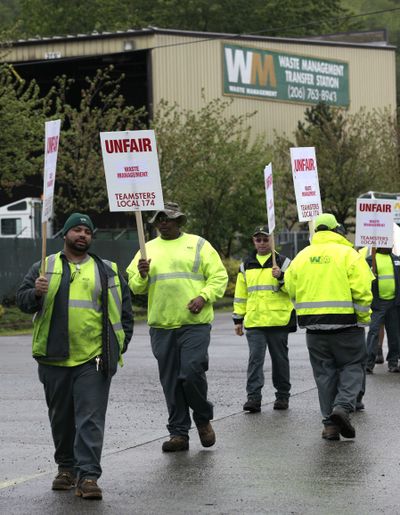 Striking workers form a picket line at a Waste Management Inc. facility in Seattle on Wednesday. Seattle-area garbage workers represented by Teamsters union Local 174 went on strike Wednesday morning.  (Associated Press)