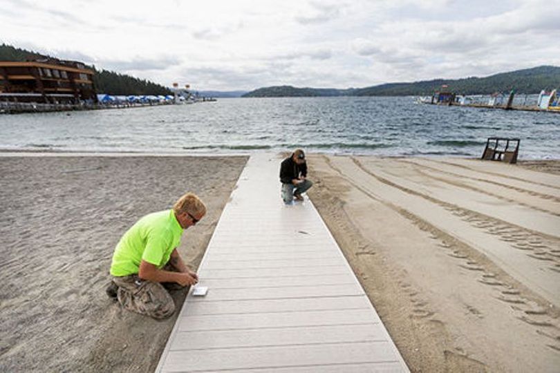 City of Coeur d’Alene Parks Department workers Toby Council, left, and Jarrod O’Dell install solar-powered lights on the edges of a new handicap-accessible boardwalk at the city beach near Independence Point Monday during their shift. (Shawn Gust / Coeur d'Alene Press)