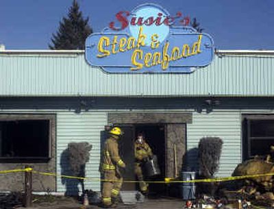 
Spokane Valley firefighters bring out debris Monday from the burned Susie's Steak and Seafood, 9611 E. Trent Ave.
 (Liz Kishimoto / The Spokesman-Review)