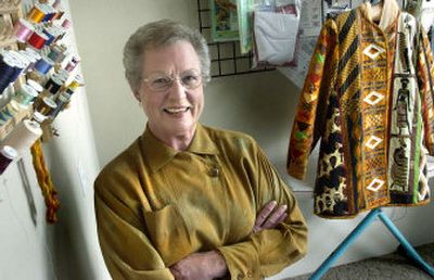 
Liberty Lake quilter  Judi Conroy poses in her basement workroom. Conroy uses her background in quilting and sewing to create textured, layered designs like the jacket hanging behind her. 
 (Joe Barrentine / The Spokesman-Review)