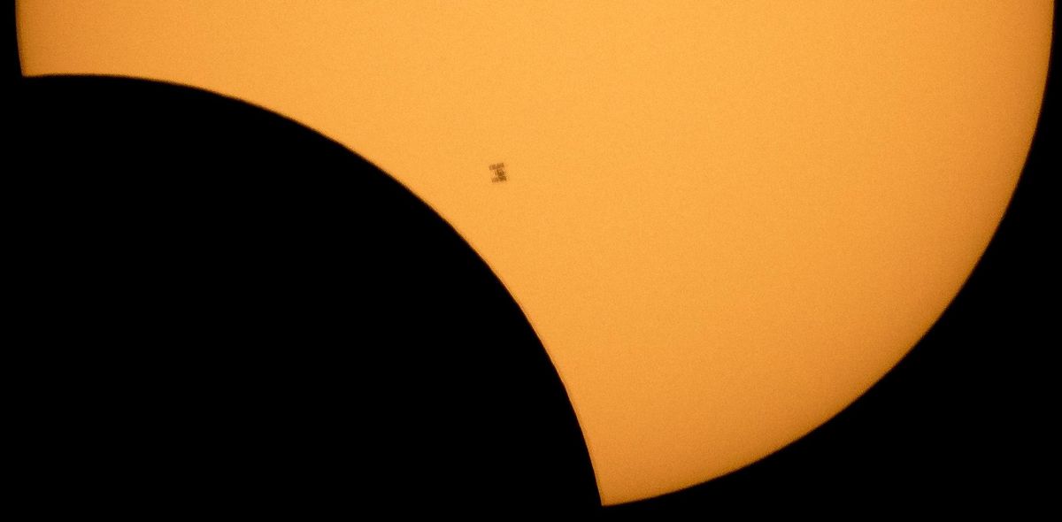 The International Space Station is seen in silhouette as it transits the sun during a partial solar eclipse, Monday, Aug. 21, 2017, from Ross Lake, Northern Cascades National Park, in Washington. (Bill Ingalls / Associated Press)