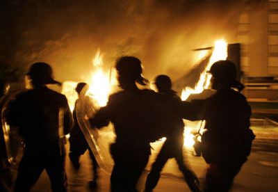 
French riot police run past a burning truck in Aulnay-sous-Bois early today. For a seventh straight night, youths set fire to cars and shops in Paris suburbs.
 (Associated Press / The Spokesman-Review)