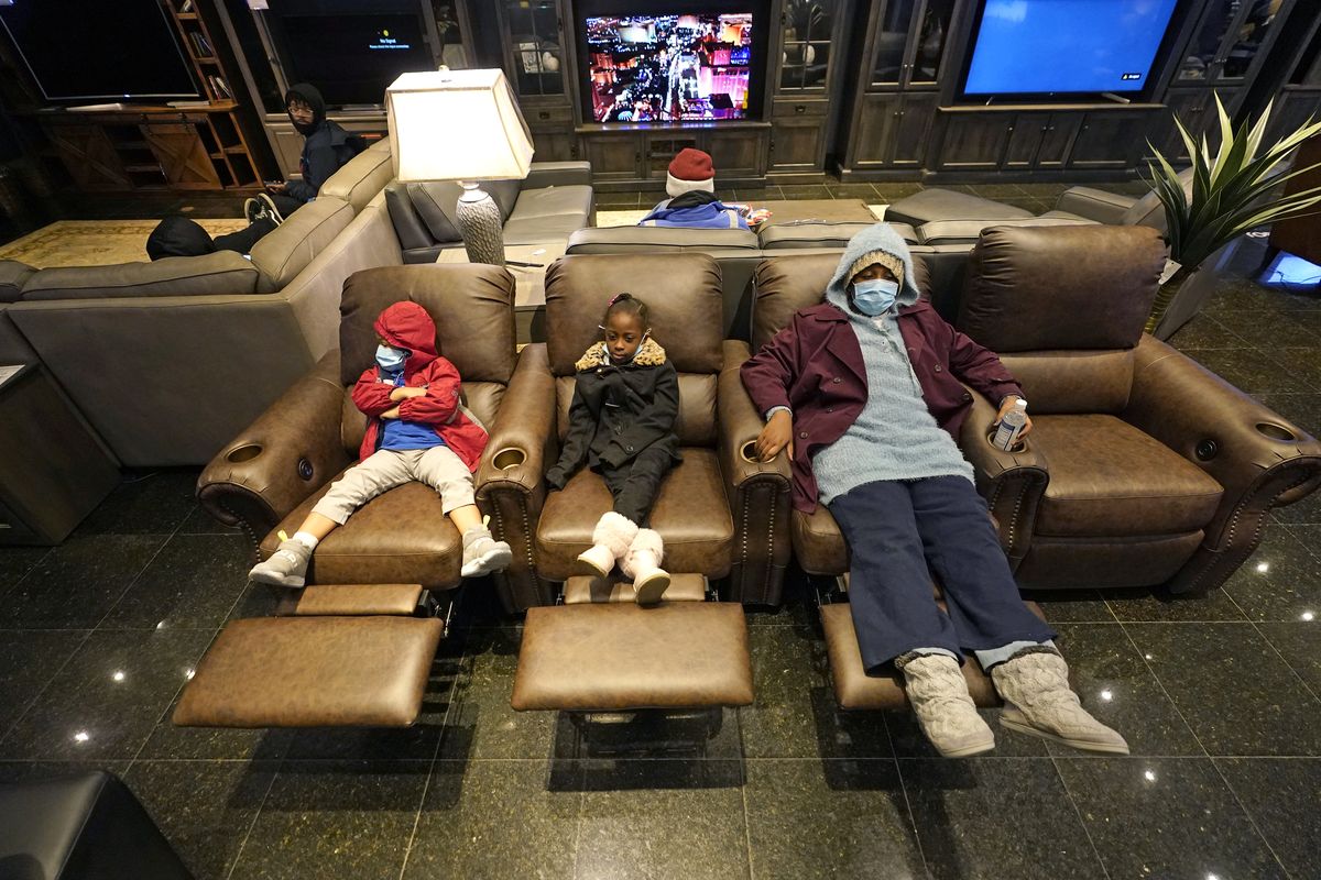 Joecyah Heath, left, Morning Day, center, and Jenesis Heath rest in recliners Wednesday at a Gallery Furniture store that opened as a shelter in Houston.  (David J. Phillip)