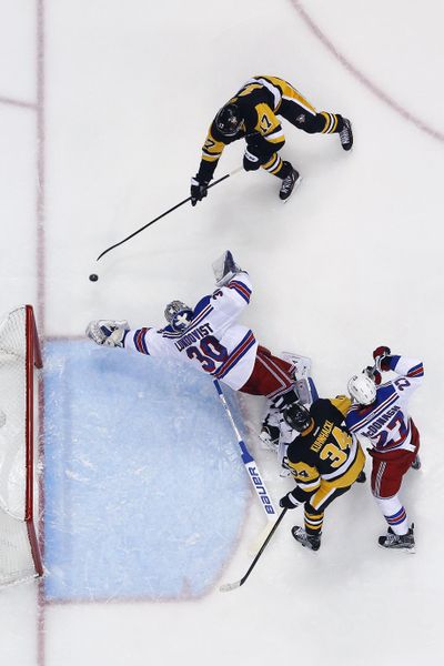 Penguins' Bryan Rust, top, gets a shot past leaping Rangers goalie Henrik Lundqvist, middle, for a goal during the second period. (Gene J. Puskar / Associated Press)
