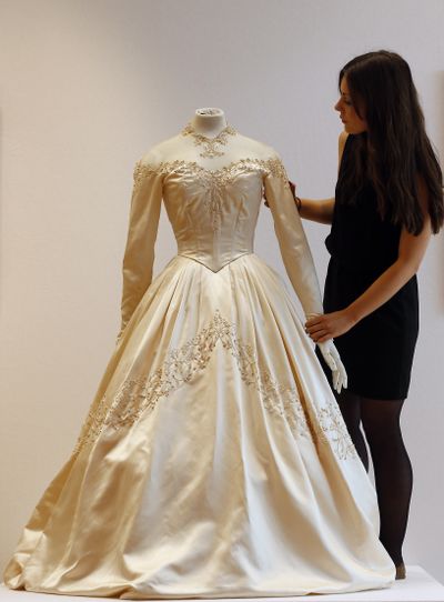 A Christie's employee adjusts Elizabeth Taylor's first wedding dress, designed by the legendary costume designer Helen Rose, at the auction house Christie's in London, Wednesday, June 19, 2013. The wedding dress is part of the auction 120 years of Pop Culture, which is showcasing important memorabilia dating from every decade of the past century of popular culture from the ubiquitous industries of film and music. The estimated price is 30,000 � 50,000 pound (46,000-78,000 dollars). (Frank Augstein / Associated Press)