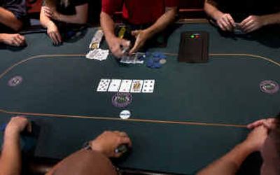 
The dealer shows his cards during a hand of Texas Hold 'Em poker at Players and Spectators. 
 (Holly Pickett / The Spokesman-Review)