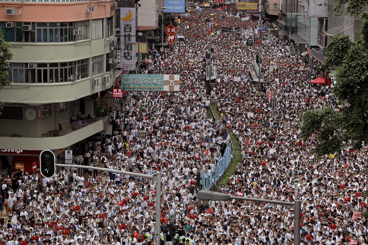 Protesters march along a downtown street in Hong Kong on Sunday against the proposed amendments to an extradition law that would allow people to be extradited to mainland China to face charges. (Vincent Yu / Associated Press)