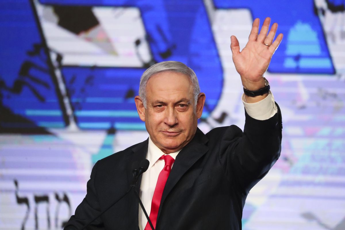 Israeli Prime Minister Benjamin Netanyahu waves to his supporters Wednesday after the first exit poll results for the Israeli parliamentary elections at his Likud party’s headquarters in Jerusalem. (Ariel Schalit)