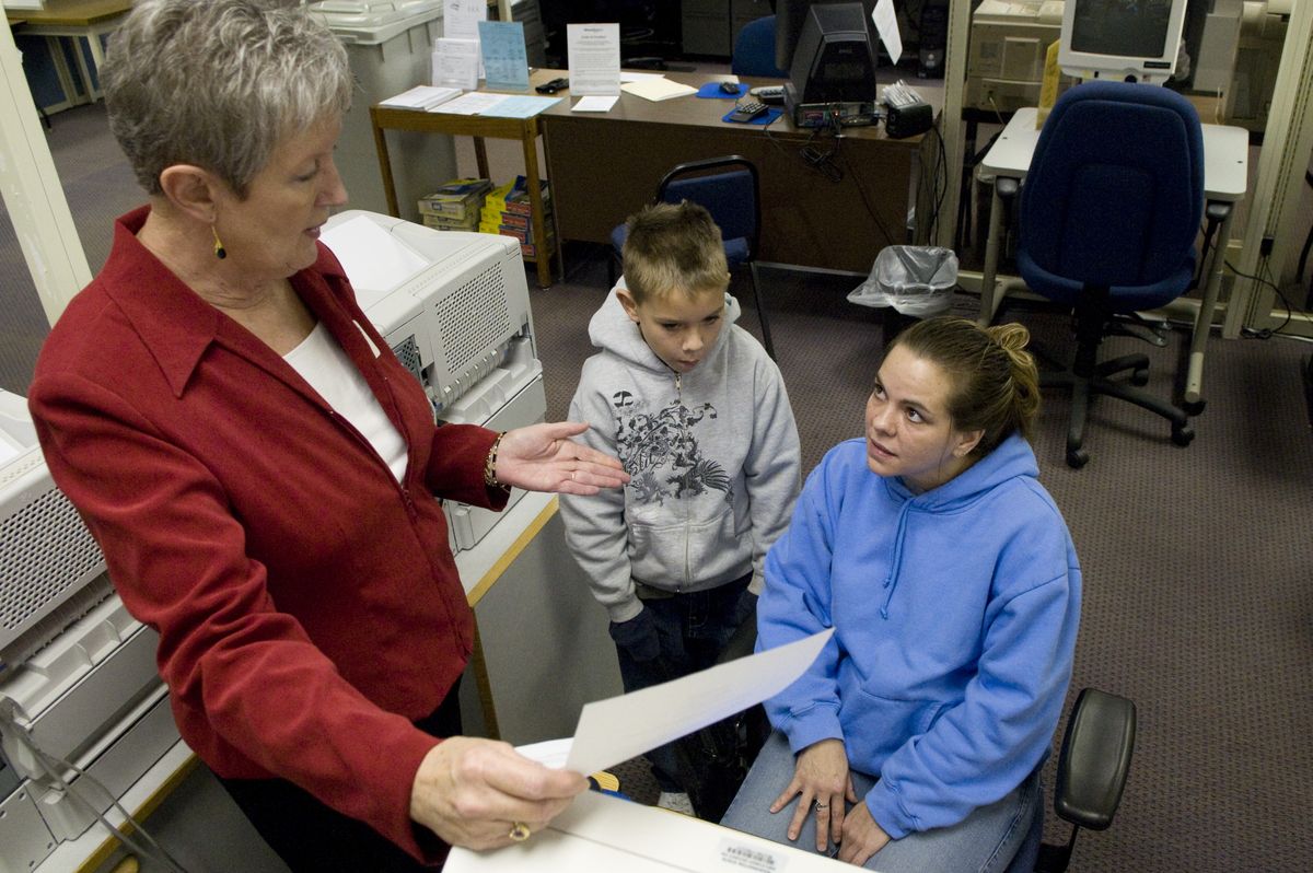 Hunter Plummer, 9, waits patiently while his mother, Kimberley Plummer, right, talks with Mollie Patshkowski, a business solutions manager with WorkSource, about her job search. Plummer was laid off from Kaiser Aluminum in October and has been looking for work ever since.  (Photos by Colin Mulvany / The Spokesman-Review)