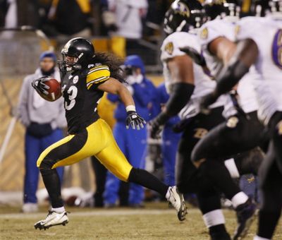 Pittsburgh Steelers' Troy Polamalu runs for a 40-yard touchdown after catching an interception pass from Baltimore Ravens quarterback Kyle Boller during the fourth quarter of the NFL AFC championship football game in Pittsburgh today. (Julie Jacobson / The Associated Press)