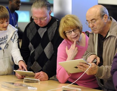 In this file photo taken earlier this month, Angelo Tortola, right, and Marianne Tortola, of Boston, look at an iPad at the Apple store on Fifth Avenue in New York.  (File Associated Press)