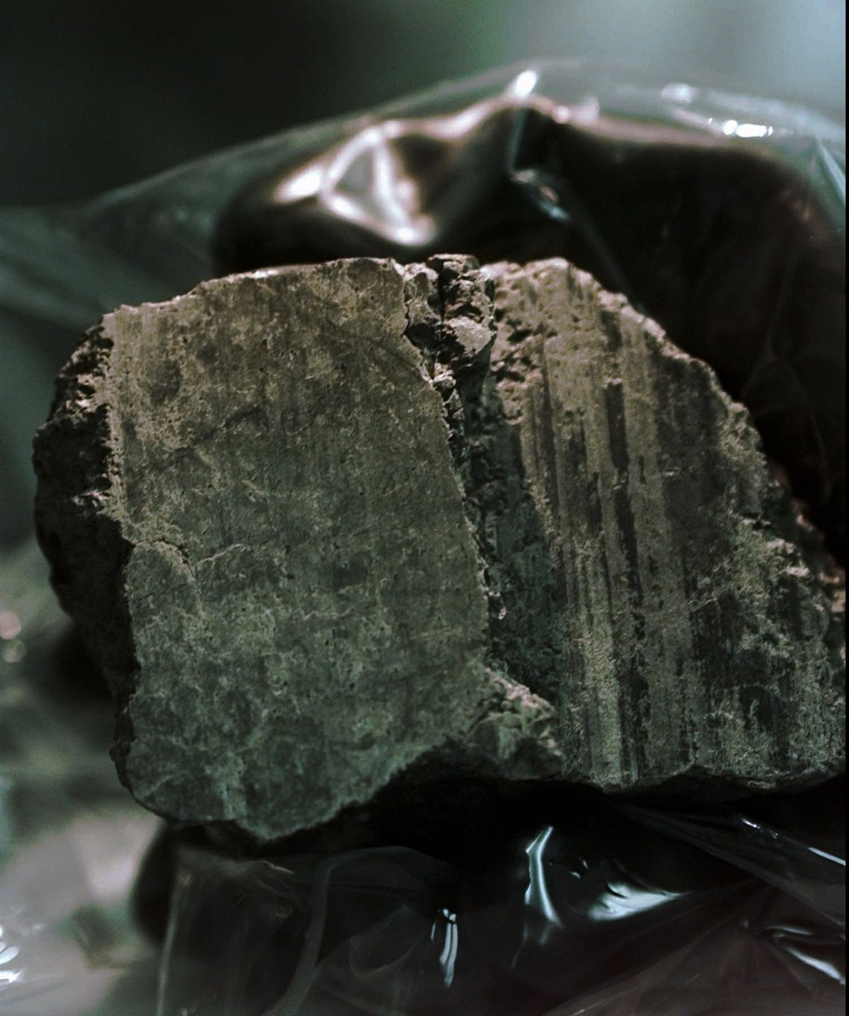The meteorite labeled ALH84001 is held in the hand of a scientist at a Johnson Space Center lab in Houston, Aug. 7, 1996. Scientists say they've confirmed the meteorite from Mars contains no evidence of ancient Martian life. The rock caused a splash 25 years ago when a NASA-led team announced that its organic compounds may have been left by living creatures, however primitive. Researchers chipped away at that theory over the decades. A team of scientists led by Andrew Steele of the Carnegie Institution published their findings Thursday, Jan. 13, 2022.  (DAVID J. PHILLIP)