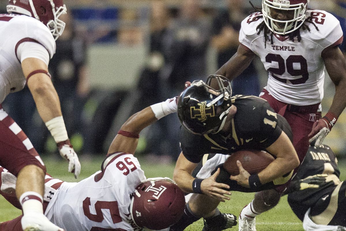 Idaho QB Chad Chalich gets his helmet spun around as he’s brought down by Temple’s Sharif Finch in the second quarter. (Associated Press)