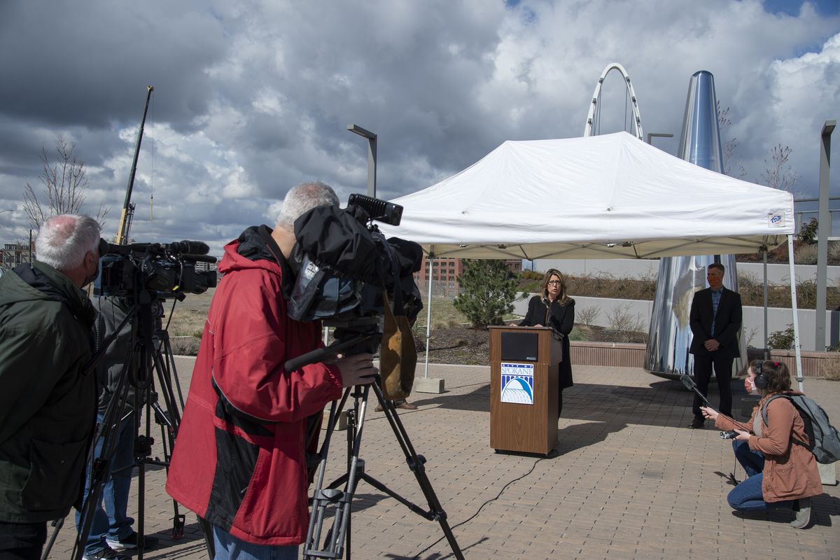 Mayor Nadine Woodward, center, speaks to the media Thursday near the south landing of the University District Gateway Bridge about the city of Spokane’s planned construction projects for the summer.  (Jesse Tinsley/THE SPOKESMAN-REVIEW)