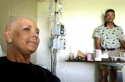 
Anna Meyer, left, a popular advertising executive at the Coeur d'Alene Press, has faced several types of cancer in the last few years and is still living day to day while continuing with various surgeries and chemotherapies. Her husband, Marshall, right, waits by her bedside. Anna's friends are throwing benefits to raise money for expensive treatments that her insurance doesn't cover. 
 (Jesse Tinsley/The Spokesman-Revi / The Spokesman-Review)