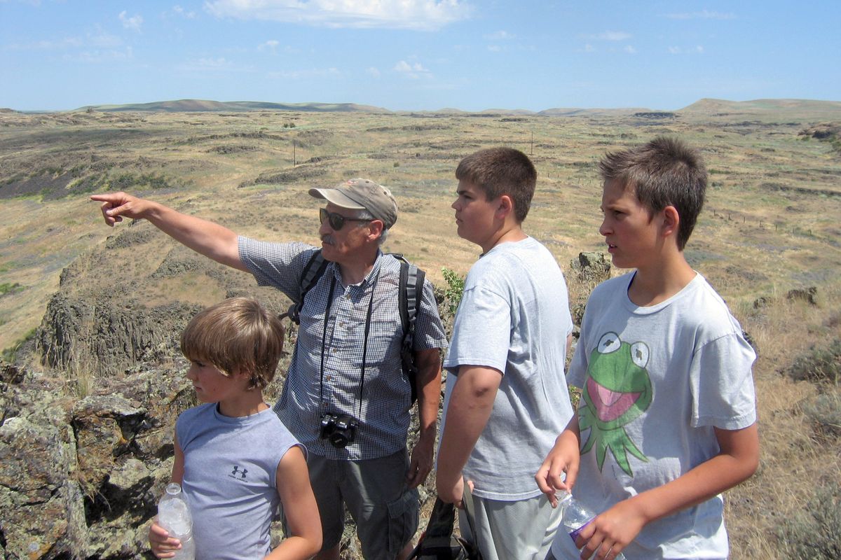 EWU anthropology professor Jerry Galm points out topography details at Escure Ranch to Sam Bergam, front left, Max Bergam and Adam Deutsch. (Rebecca Nappi)