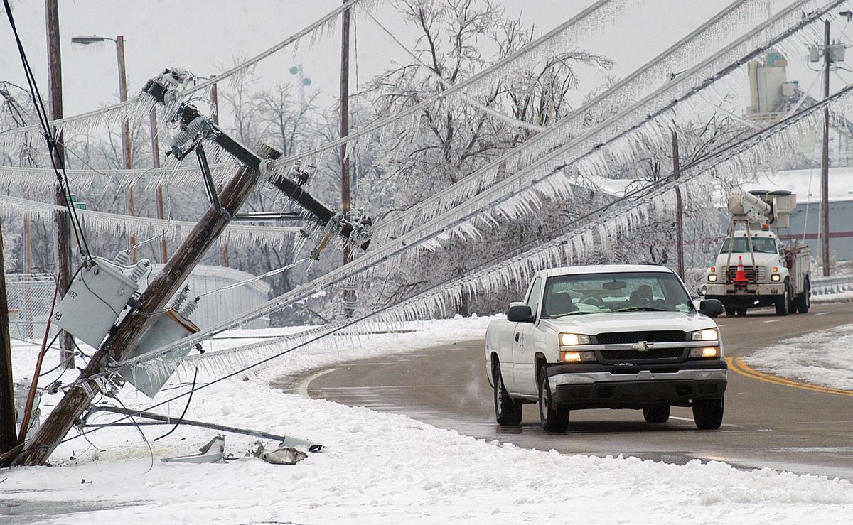 A pair of vehicles prepare to pass the top of a power pole that fell onto the sidewalk along 3rd Street in Paducah, Ky., on Saturday. Associated Press photos (Associated Press photos / The Spokesman-Review)