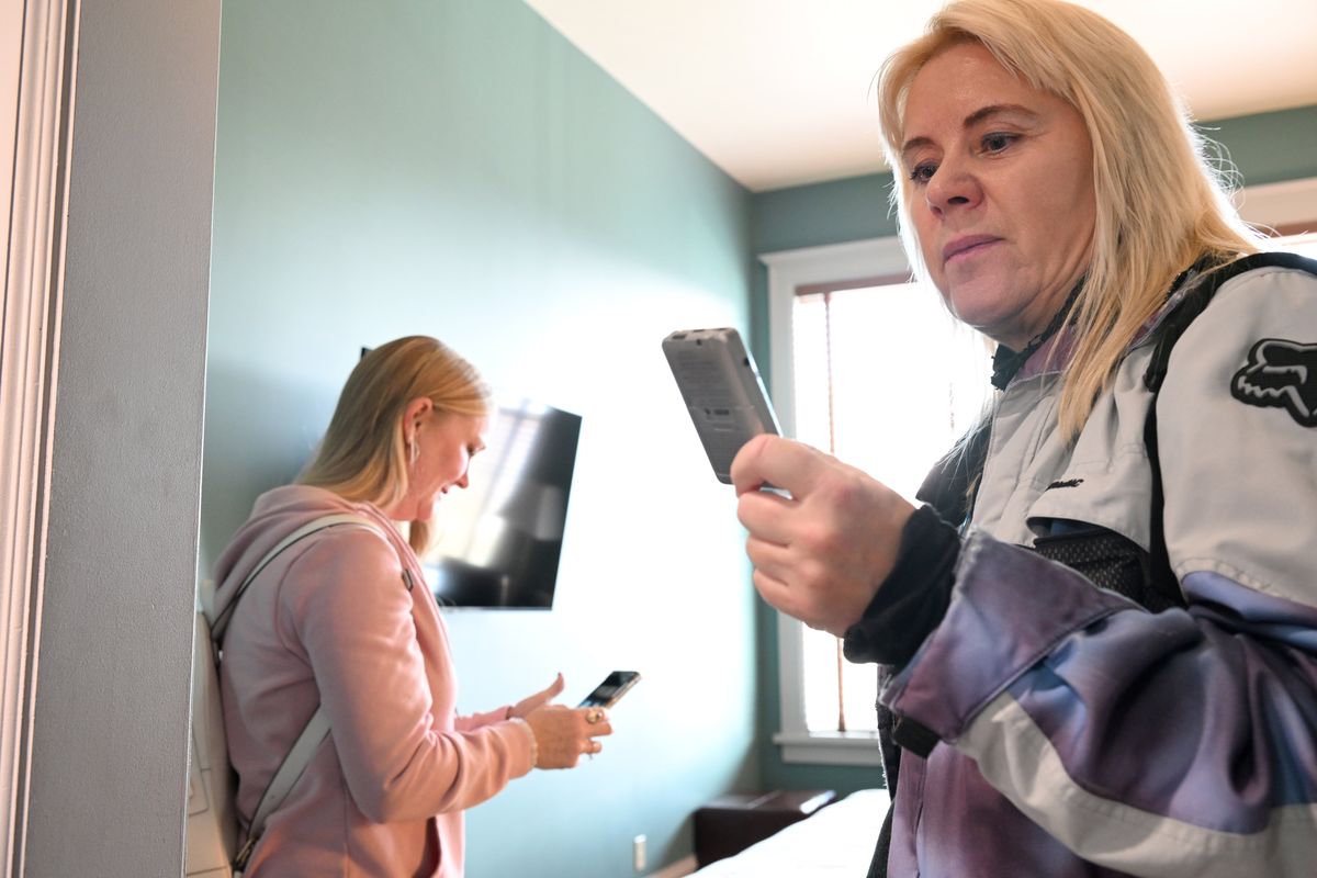 Medium Jennifer Von Behren, left, looks at her phone while paranormal investigator Kika Morelan, right, listens to a digital recorder in a room of the Montvale Hotel Thursday, October 23, 2025, while taking a tour of the historic complex. Von Behren, who said she sensed another "entity" in the room, provides her services as a psychic medium to people who request it and Morelan tries to capture paranormal activity on various technical devices, including video and audio recorders, when looking into mysterious occurrences.  (Jesse Tinsley/THE SPOKESMAN-REVIEW)