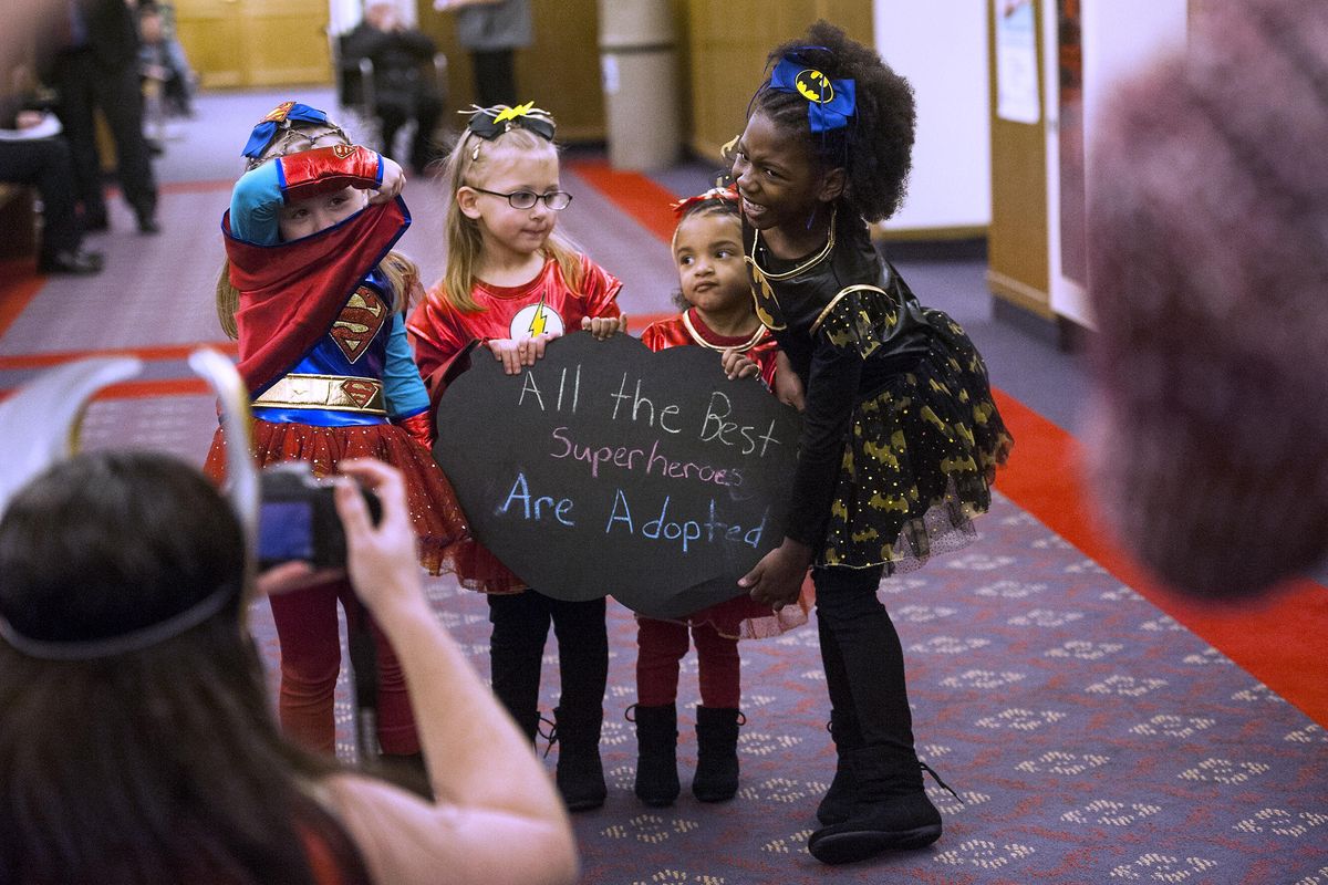 From left, Kenzie, 5, Klara, 4, Sheri, 3, and Athena, 6, pose for pictures in superhero costumes at the Spokane County Courthouse on Friday, Nov. 17, 2017, in observance of National Adoption Day. Each child has been adopted into the Wisner family. The newest addition, Sheri, was adopted on Friday. (Kathy Plonka / The Spokesman-Review)