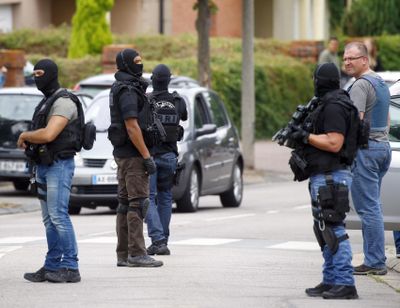 Police officers conduct a search in Saint-Etienne-du-Rouvray, Normandy, France, following an attack on a church that left a priest dead, Tuesday, July 26, 2016. (Francois Mori / Associated Press)