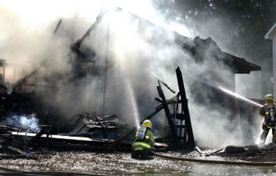 
Spokane Valley firefighters douse the home on the 9700 block of East Whitman in Spokane Valley on Wednesday. The cause of the fire is under investigation. 
 (Liz Kishimoto / The Spokesman-Review)