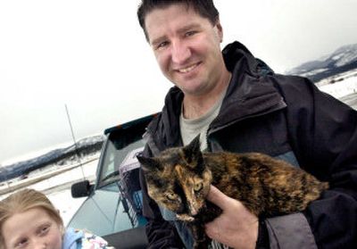 
Missoula firefighter Josh Macrow holds the cat that he and another firefighter rescued from the ice on the Clark Fork River in Missoula on Tuesday. At left is Macrow's daughter Taylor Macrow, 12. 
 (Associated Press / The Spokesman-Review)